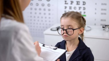 Optometrist çocuk, göz tedavisi önerileri üzgün gözlük reçete