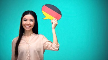 Alman bayrağı konuşma balonu tutan gülümseyen kız, dil öğrenme, seyahat fikirleri