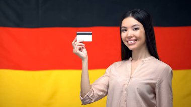 Alman bayrağına karşı kredi kartı tutan kadın, uluslararası para transferi