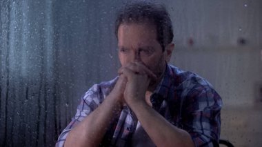 Umutsuz adam yağmurlu günde yaşam ve sağlık sorunları hakkında düşünme, depresyon