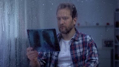 Üzgün erkek tutan x-ray, akciğerler kanser tanısı, şok ve çaresiz duygu