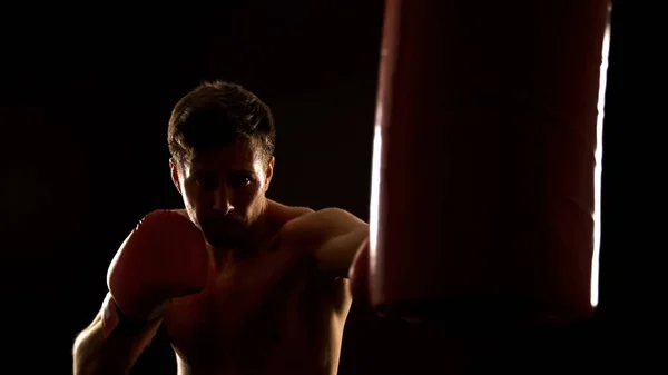 男性ボクサーパンチボクシングバッグ 競争の前にウォームアップ — ストック写真