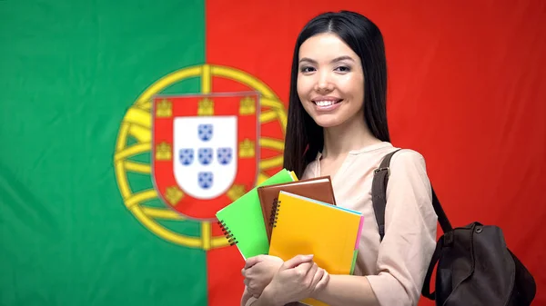 Asiática Mujer Estudiante Celebración Copybooks Contra Portugués Bandera Fondo — Foto de Stock