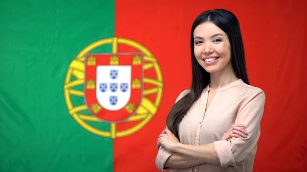 ポルトガルの旗の背景に対して手を組んで立っている笑顔の女性 — ストック写真