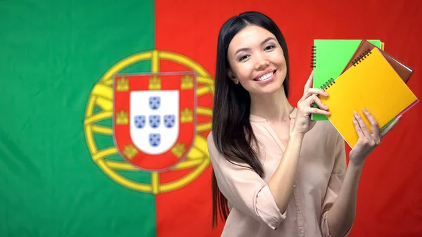 Mujer Sosteniendo Copybooks Contra Fondo Bandera Portuguesa Aprendiendo Idioma — Foto de Stock