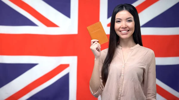 Sorrindo Menina Asiática Segurando Passaporte Contra Fundo Bandeira Britânica Cidadania — Fotografia de Stock