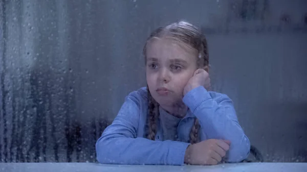 Μοναχικό Κορίτσι Κοιτάζοντας Παράθυρο Βροχερό Καιρό Περιμένοντας Τους Γονείς Από — Φωτογραφία Αρχείου