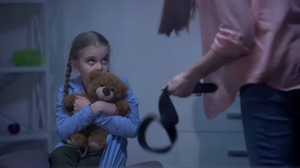 Mother Belt Threatening Scared Daughter Hugging Teddy Bear Window — Stock Photo, Image