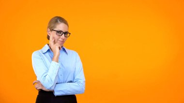 Pensive office worker looking camera on orange background, choice hesitation clipart