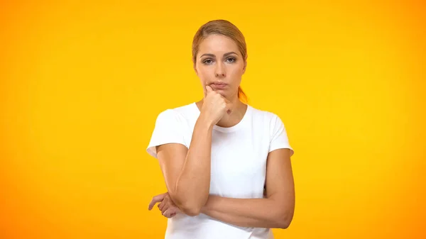 Femme Réfléchie Avec Main Sur Menton Debout Sur Fond Orange — Photo