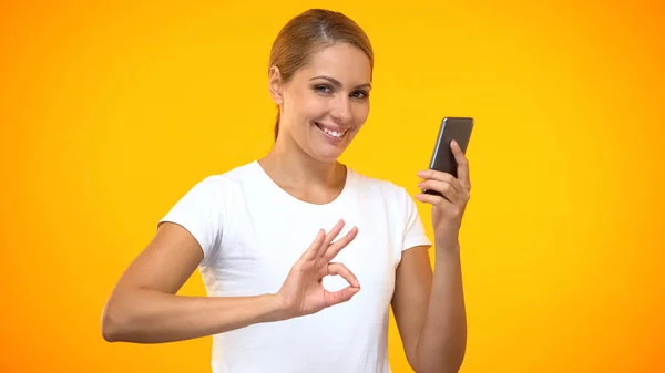Lächelnde Junge Frau Zeigt Geste Mit Smartphone Der Hand Bargeld — Stockfoto