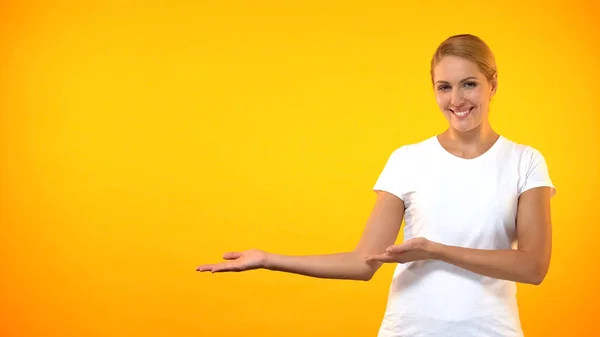 Молодая Улыбающаяся Женщина Представляет Шаблон Оранжевом Фоне Объявление — стоковое фото