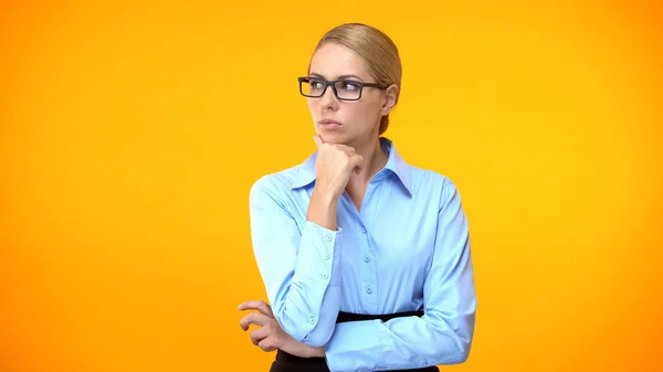 Doordachte Vrouw Kijkt Links Oranje Achtergrond Moeilijke Keuze Aarzeling — Stockfoto