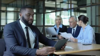 Gülümseyen Afrikalı işadamı tablet raporu okuyor, başarılı projeden memnun