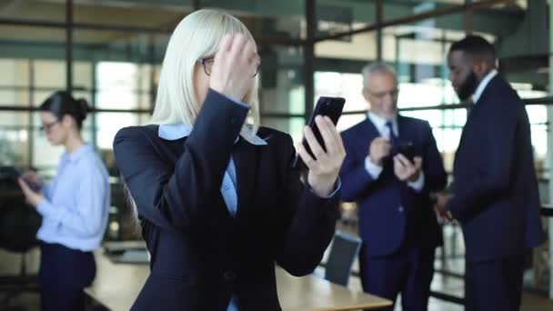 Emocionado smartphone mulher de negócios mostrando gesto de sucesso, aplicativo de negociação de ações — Vídeo de Stock