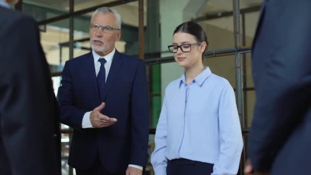 Mature boss introducing new female colleague in office, coworkers shaking hands — Stock Video