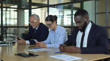 Akıllı telefonlar, iş messenger uygulaması, iyi haber kullanan gülümseyen yöneticiler