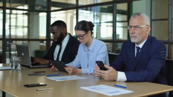 Akıllı telefon, tablet ve dizüstü bilgisayarda çalışan çok ırklı ofis çalışanları grubu — Stok video