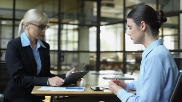 Unhappy company director scolding female employee checking sales result tablet — Stock Video