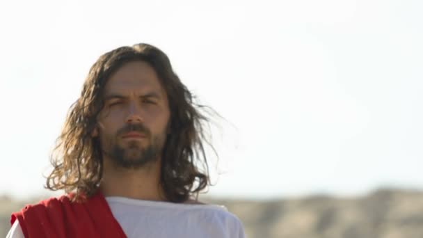Серьезный Иисус в пустыне смотрит в камеру, страдает за людей грешит, крупным планом — стоковое видео