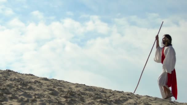 Jesus exausto com bastão em roupão e faixa andando pelo deserto, religião — Vídeo de Stock