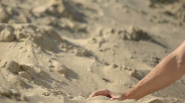 Çölde kum alan, yumruktan dökülen, barınak arayan gezginin eli