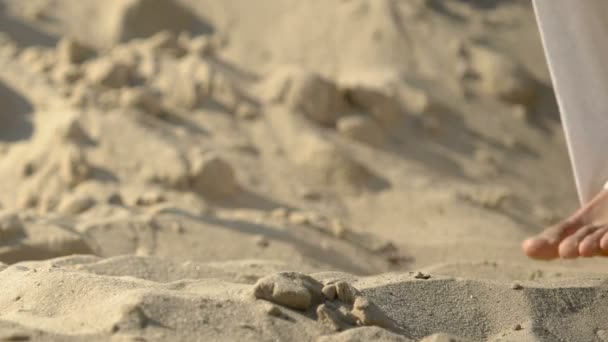 Pernas de monge em roupão andando sobre uma colina arenosa pelo deserto, em busca de oásis — Vídeo de Stock