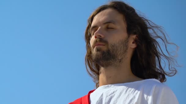 目を閉じたイエスは、人々の魂を救うために祈り、屋外で瞑想を閉じました — ストック動画