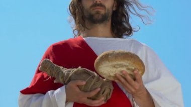 İsa cüppe ve kuşak şarap ve ekmek şişesi tutan, cennetten hediyeler