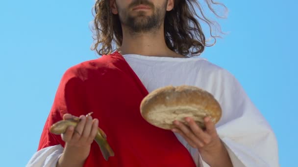 Святой Иисус Христос в мантии протягивая рыбу и хлеб в камеру, сын Божий — стоковое видео