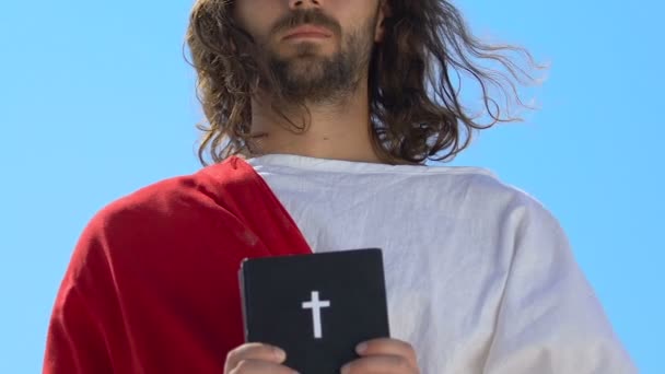 Jesus em roupão mostrando Bíblia Sagrada na câmera, fé e crença conceito, religião — Vídeo de Stock