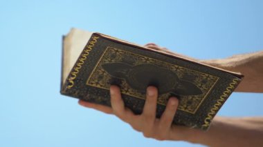 Kuran kitabı okuyan, gök arka planda Allah'a dua eden adam, İslami öğretiler