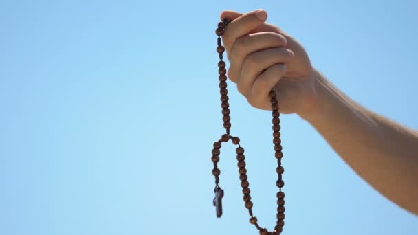 Mann mit Rosenkranz betet zu Gott auf Himmelshintergrund, Sühne für Sünde, Nahaufnahme — Stockvideo