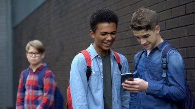 Two bully boys posting offensive video about upset guy behind, cyberbullying clipart