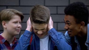 Depresif çocuk alay ve okul arkadaşlarının hakaret, zorbalık kulaklarını kapsayan