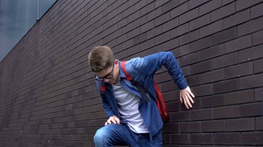 Duvara yakın yatan, kendini kötü hisseden, ani acı çeken, sağlık sorunu olan bir öğrenci.