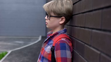 Üzgün okul çocuğu duvara yakın duran, zorba çocukların istatistikleri, farkındalık