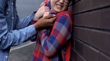 Agresif genç duvara çocuk iterek, fiziksel zarar zorbalık tehdit