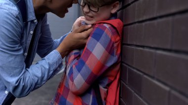 Agresif genç çocuk zayıf zorbalık, fiziksel istismar, tehdit ile korkutucu