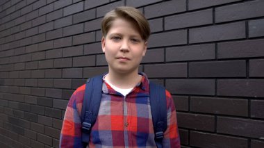 Duvara yakın sırt çantası ile Pozitif çocuk, mükemmel öğrenci, başarılı bir öğretim yılı