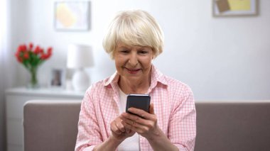 Akıllı telefon, online alışveriş, sosyal ağ sohbet kullanarak pozitif yaşlı kadın