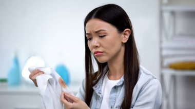 Üzgün ev hanımı kahve leke, çamaşır hane, spot çıkarıcı ile gömlek tutan