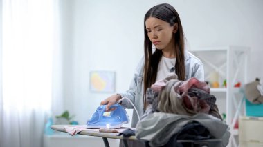 Yorgun ev hanımı gemide giysi ütüleme, ev sorumlulukları, fazla çalışma