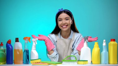 Gülümseyen ev hanımı deterjan çeşitleri sunan, temizlik şirketi hizmeti