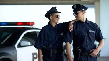 Üniforma ve gözlüklü pozitif polis memurları birlikte gülümsüyor, kanun ve düzen