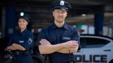 Polis karakolu yakınında gülümseyen nazik polis memurları, yardıma hazır, düzen