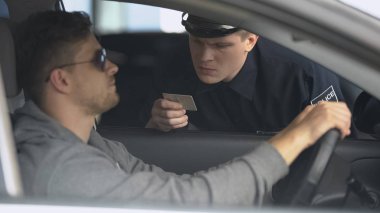 Hız sınırını aştıktan sonra erkek sürücü belgesi kontrol ciddi polis