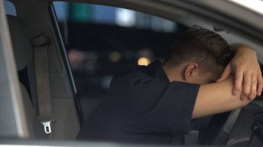 Erkek sürücü direksiyonda sızan, işten sonra yorgun, araba kazası riski