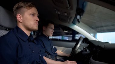 Arabada oturan polis memuru, birlikte şehirde devriye gezen, düzenin korunması