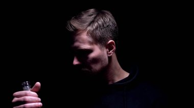 Votka şişesi tutan bağımlı adam, alkol bağımlılığı sorunu, sağlıksız alışkanlık